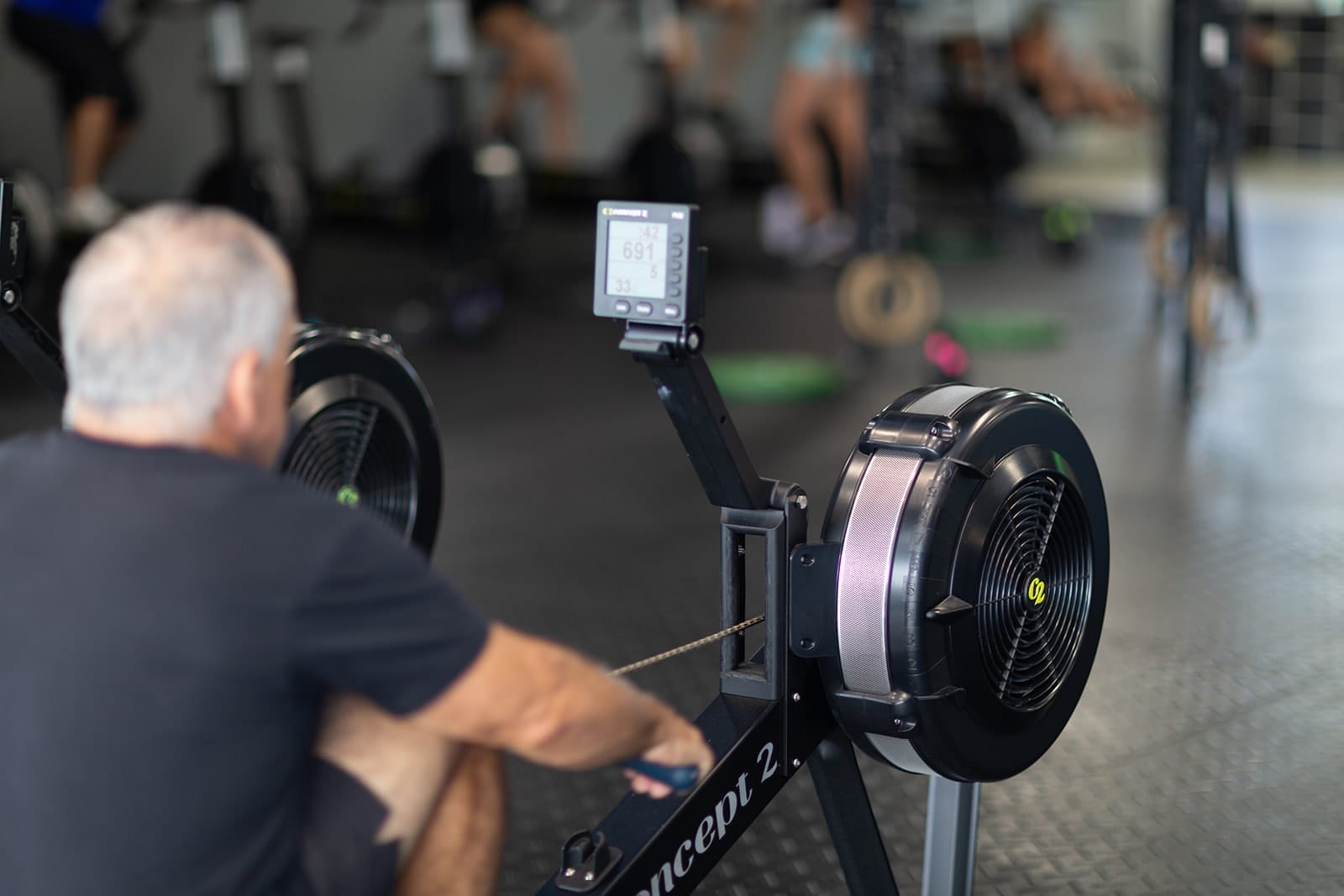 Man training on a rowing machine in a gym