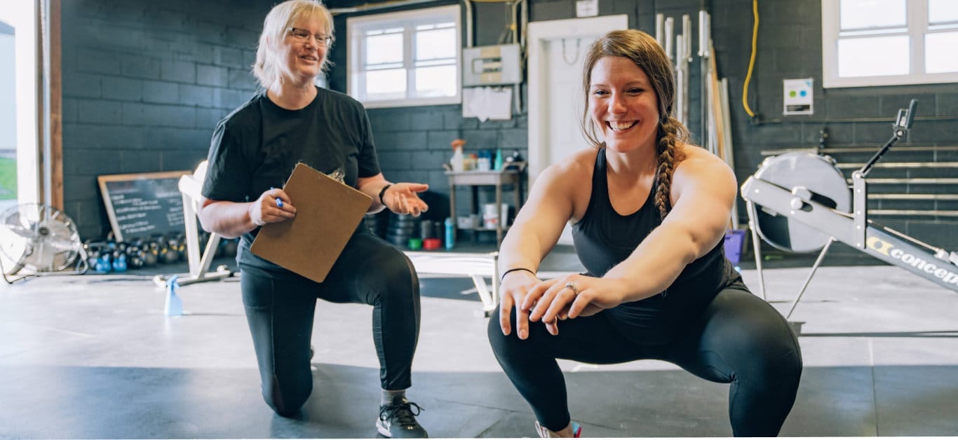 Woman smiling while working out with her coach